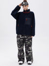 Pantalon de ski ample et fluide pour femme, en polaire imitation sherpa avec fermeture éclair intégrale et genoux renforcés.
