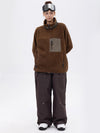 Pantalon de ski ample et fluide pour femme, en polaire imitation sherpa avec fermeture éclair intégrale et genoux renforcés.