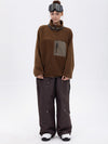 Pantalon de ski ample et fluide pour femme, en polaire imitation sherpa avec fermeture éclair intégrale et genoux renforcés.