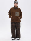 Pantalon de ski ample et fluide pour femme, en polaire imitation sherpa avec fermeture éclair intégrale et genoux renforcés.