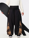 Pantalon de jogging ample de ski pour homme, style graffiti, avec empiècements colorés et bandes réfléchissantes.